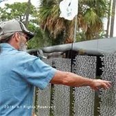 A man holding out his hand to point at a name on the Vietnam Traveling Wall