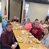 A table of senior center members enjoying a meal together