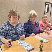 Three senior center members playing bingo together