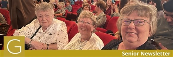 Three senior center members sitting in red chairs at the Ohio Theatre before a show