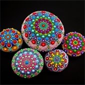 A group of painted rocks with a black background