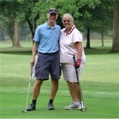 Two senior center members smiling together on a golf course