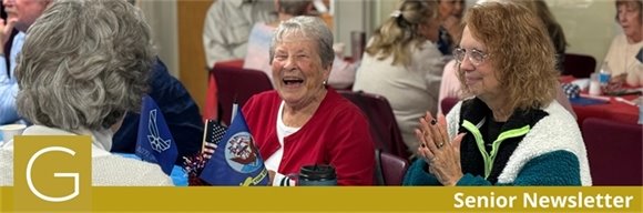 Senior center members having a conversation and laughing together seated at a table