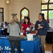 A mother and daughter speaking with a vendor at the Senior Expo