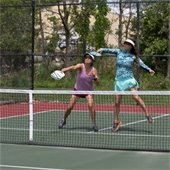 Two women playing Pickleball together on the same team