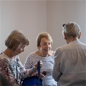 Three people talking at a Senior Center event