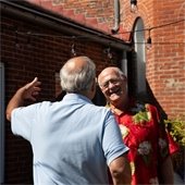Two senior center members coming together for a hug