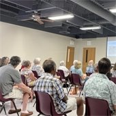 a group of senior center members listening to a presentation