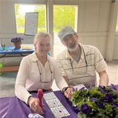 Two Senior Center members smiling at a park table while they play bingo