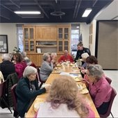 A table full of senior center residents enjoying a meal together