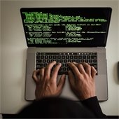 hands typing html code on a laptop