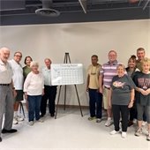 Group of Senior Center members posing for the camera with their Beanbag Baseball scoreboard