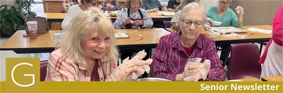 Two senior center members making cookies and smiling