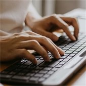 Hands typing on a keyboard
