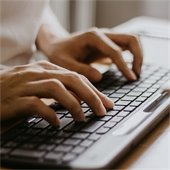 two hands typing on a keyboard