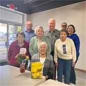 Group of senior center members smiling with a birthday card