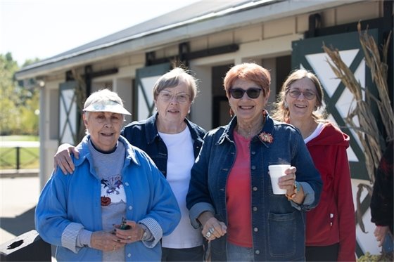Four senior center members standing together outside and smiling
