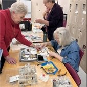 Senior Center members making jewelry together at a table