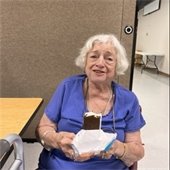 A senior center member eating an ice cream sandwich