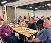 a table with senior center members having a meal together and smiling