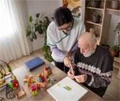 a healthcare provider working with an elderly patient on memory activities