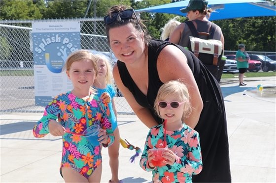 A mother and two children smiling with snow cones