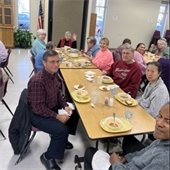 a table of senior center members enjoy a soup lunch