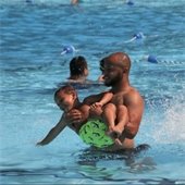 a father holding his son in a swimming pool
