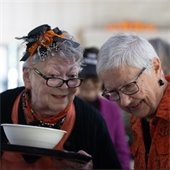 Two senior center members talking over a meal at the Fall Fireside Feast