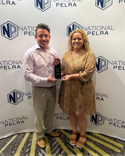 Sr. Director of Administrative Services and HR Manager with NPELRA award in front of a step and repeat