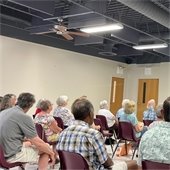 A room full of senior center members sitting in chairs listening to a presentation