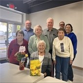Senior Center members smiling in a group, celebrating someone's 100th birthday