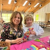 two senior center members at a picnic table doing a craft together