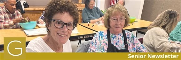Two senior center members making cookies and smiling