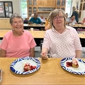 Two senior center members having dessert together