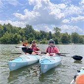 Two women in kayaks smiling for a photo