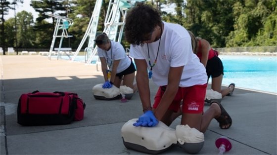 three American Red Cross participants practicing CPR on a mannequin