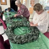 two senior center members working on decorating wreaths