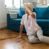 A senior citizen on the floor holding their head