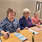 Three senior center members playing bingo together
