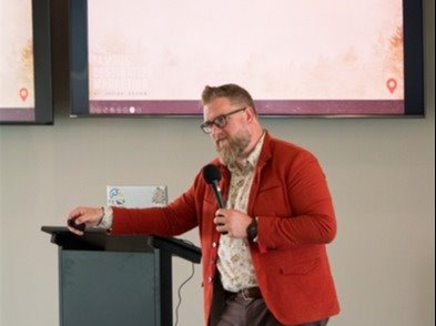 Josiah Brown holding a microphone giving a presentation