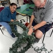 two senior center members working on decorating holiday wreaths