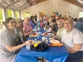 Senior Center members at a table outside together and smiling