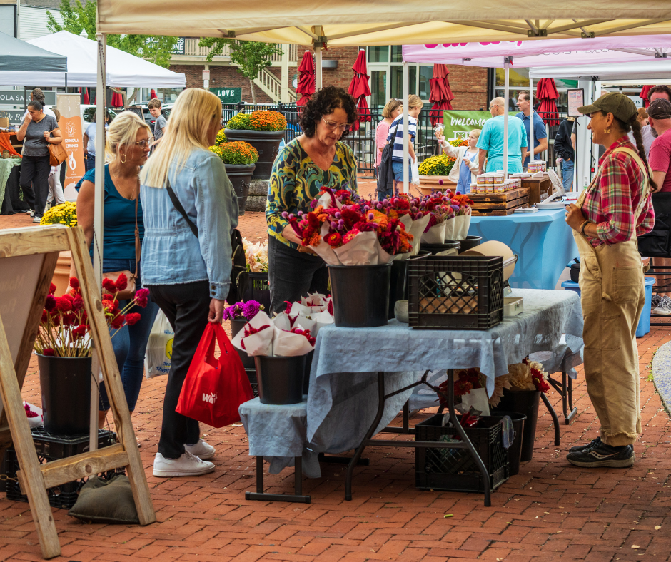 Patrons shopping for flowers from a flower farm vendor at the Gahanna Market